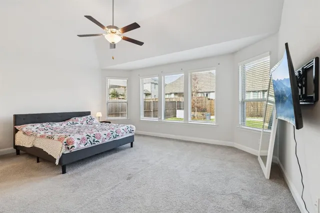 a bedroom with a bed a window and a flat screen tv