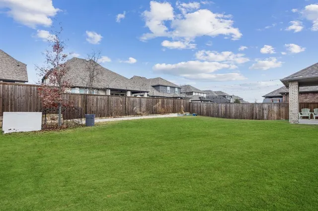a view of a backyard with a garden and outdoor seating