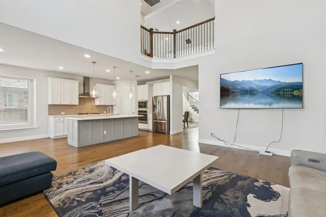 a living room with stainless steel appliances furniture and a kitchen view