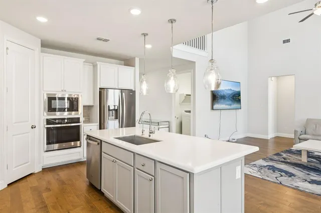a kitchen with stainless steel appliances kitchen island granite countertop a sink a refrigerator and a stove
