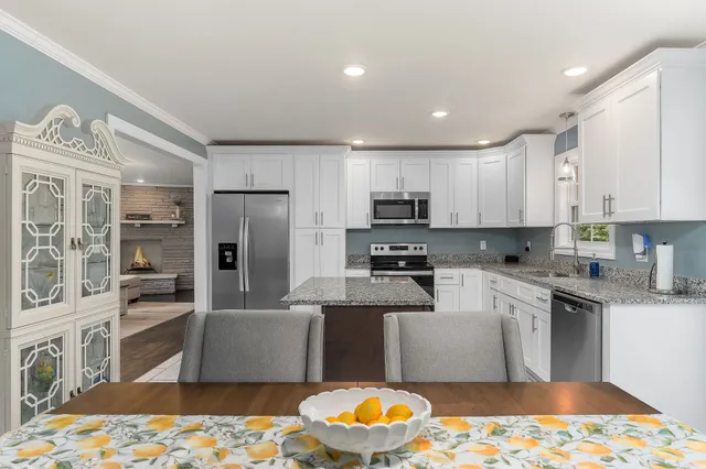 a kitchen with granite countertop a stove sink and microwave