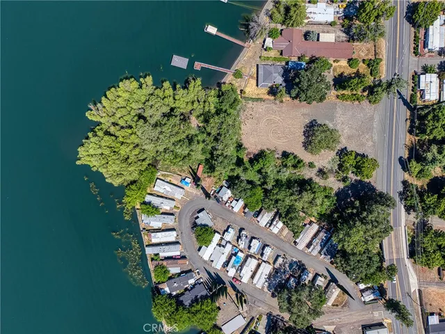 an aerial view of a house with a yard and lake view