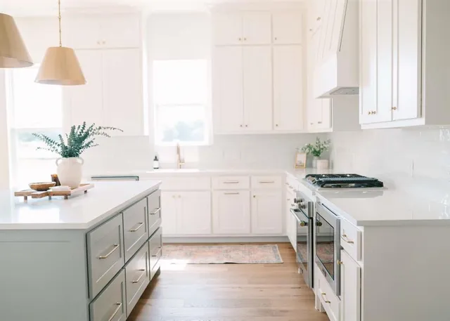a kitchen with a white cabinets and window