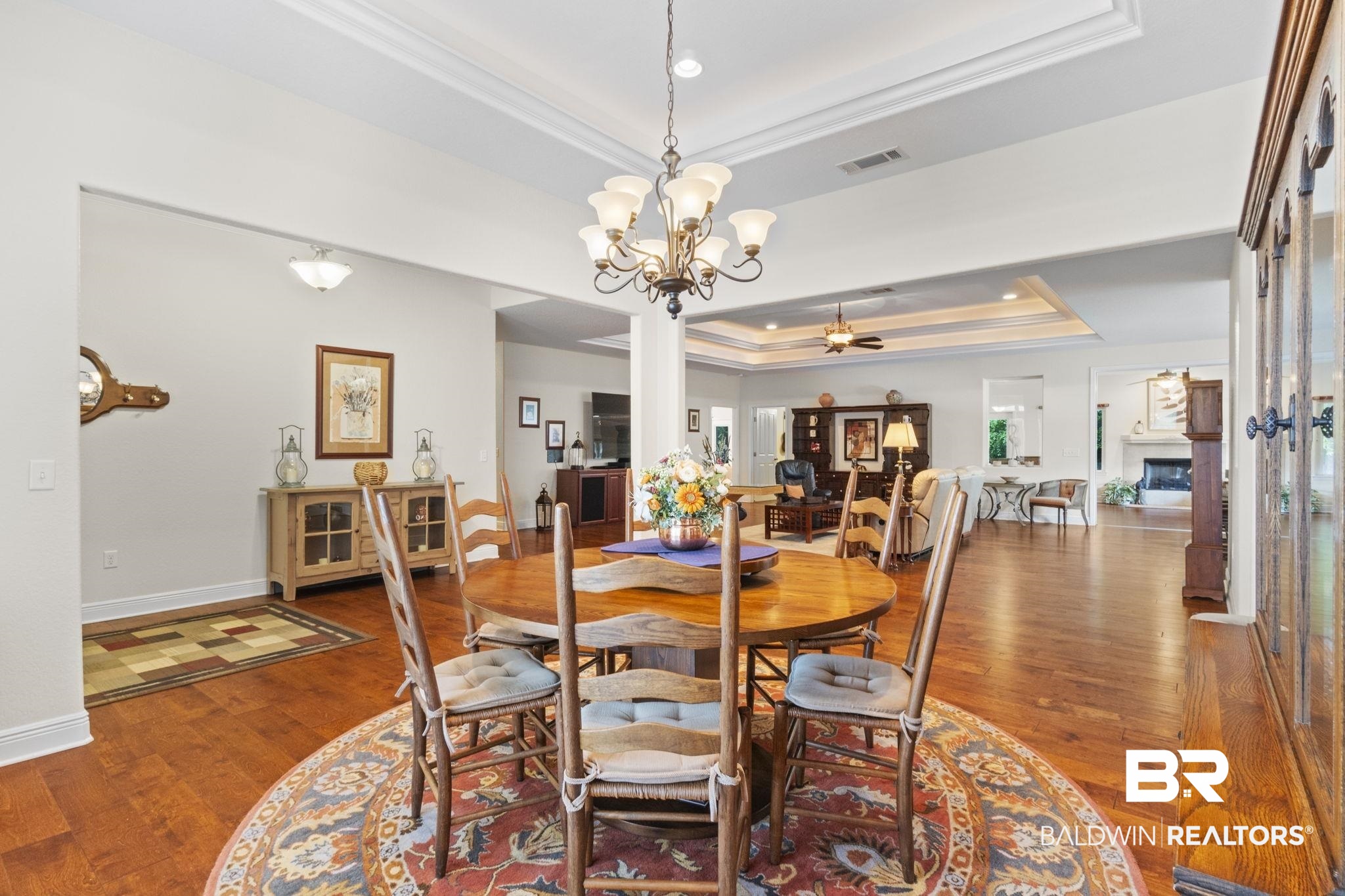 8664 Foxtail Loop Pensacola, FL 32526 - Photo 7 of 64 Dining space featuring a raised ceiling, crown molding, wood finished floors, ceiling fan, and baseboards