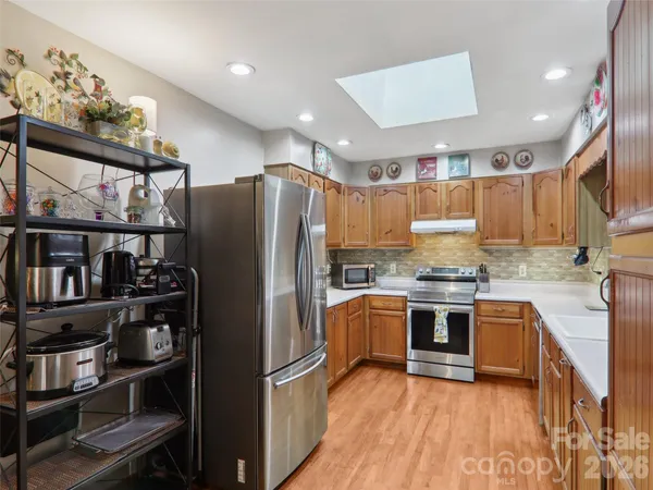 a kitchen with stainless steel appliances granite countertop a refrigerator and a stove