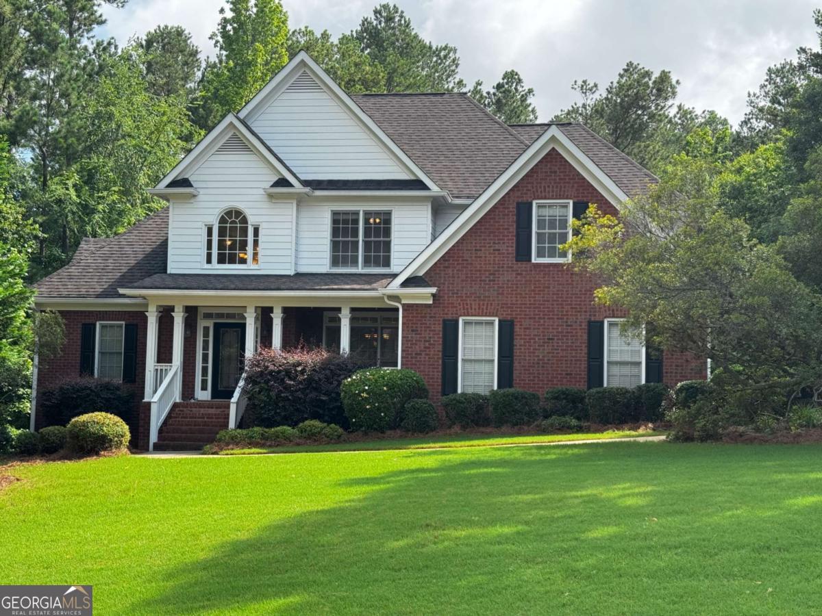 a front view of a house with a yard and potted plants