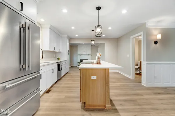a kitchen with a sink a counter top space stainless steel appliances and cabinets