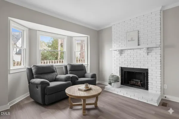 a view of empty room with wooden floor and fireplace