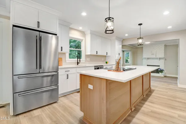 a kitchen with kitchen island a sink stainless steel appliances and cabinets