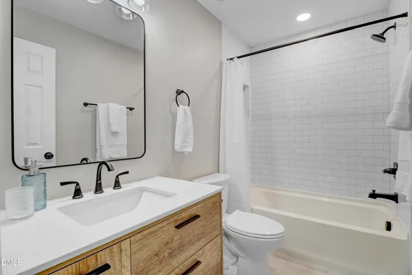 a bathroom with a double vanity sink toilet mirror and shower