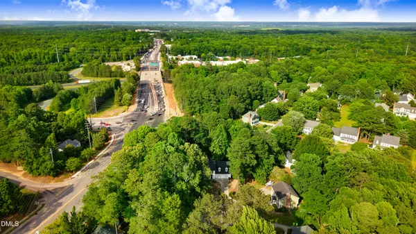 an aerial view of a house with a yard and large trees