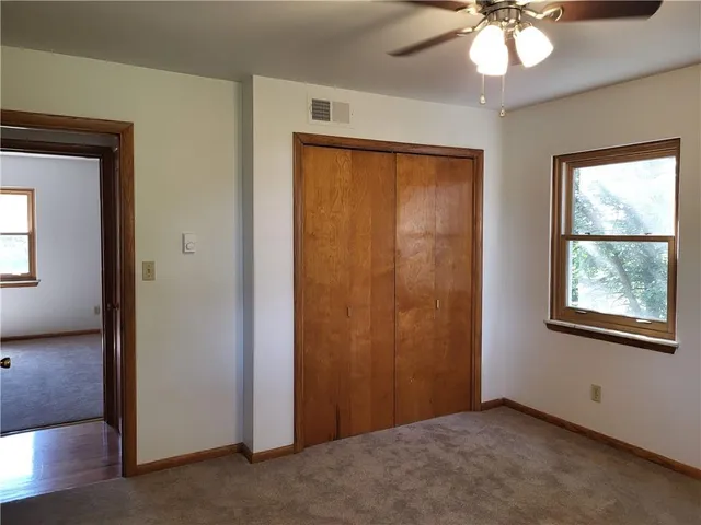 an empty room with windows and closet