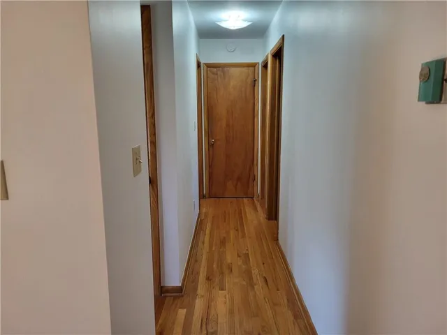 a view of a hallway with wooden floor and closet