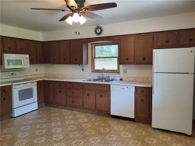 a kitchen with a refrigerator sink and cabinets