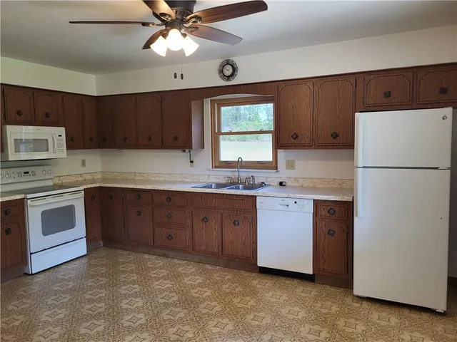 a kitchen with a refrigerator sink and cabinets