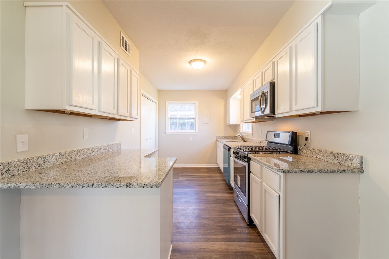 5350 Mesquite Road Memphis, TN 38120 - Photo 11 of 24 a kitchen with stainless steel appliances granite countertop a stove a sink and a granite counter tops with white cabinets