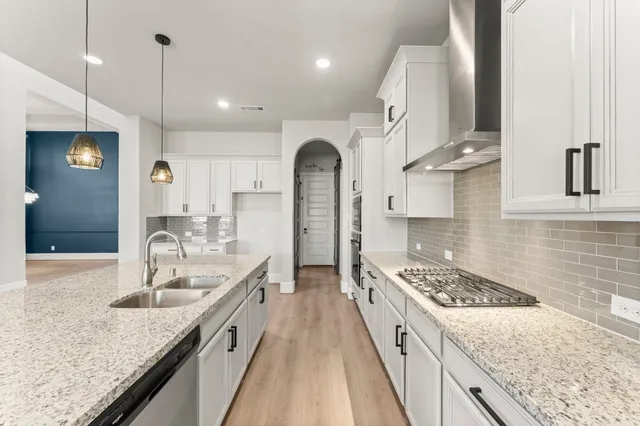 a kitchen with granite countertop a sink stove and refrigerator