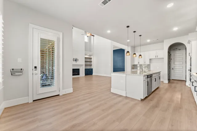 a large white kitchen with a refrigerator a sink a stove and cabinets