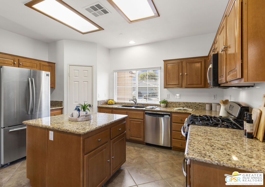 1264 Oro Ridge Palm Springs, CA 92262 - Photo 15 of 38 a kitchen with stainless steel appliances granite countertop a sink stove and refrigerator