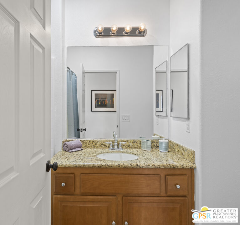 1264 Oro Ridge Palm Springs, CA 92262 - Photo 24 of 38 a bathroom with a granite countertop sink and a mirror