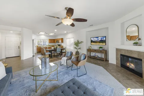 a living room with furniture kitchen view and a chandelier