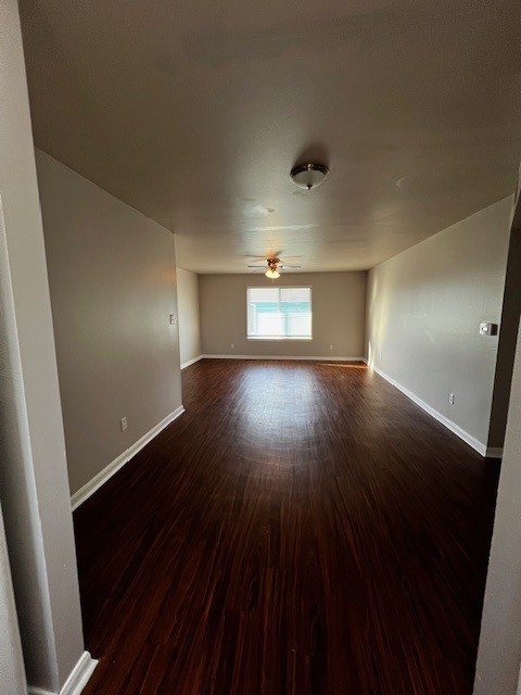 1172 Webberville Road Austin, TX 78721 - Photo 9 of 9 Empty room with dark wood-style flooring and a ceiling fan