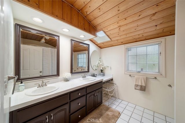 a spacious bathroom with a double vanity sink a mirror and a shower