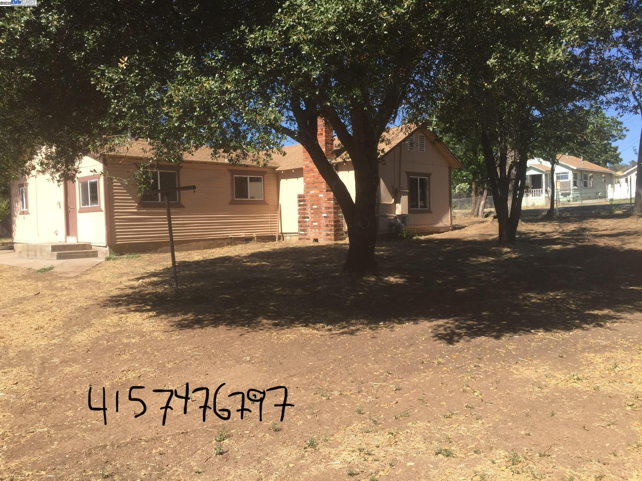 a view of a street sign under a large tree