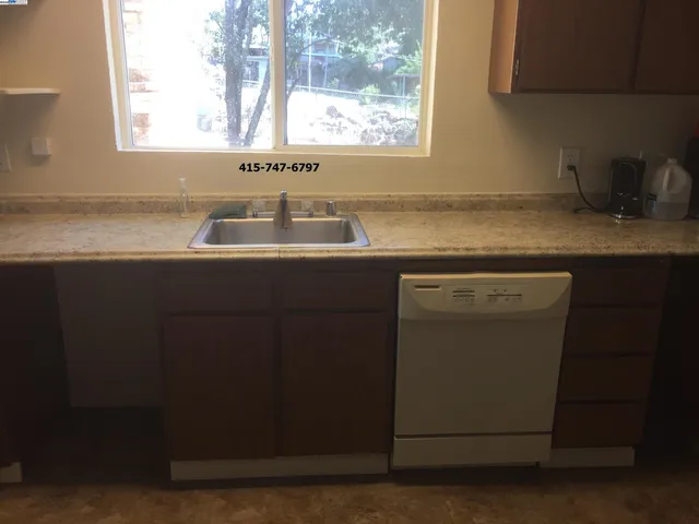 a kitchen with a sink cabinets appliances and a window