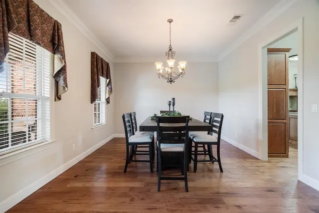 a dining room with furniture a chandelier and wooden floor