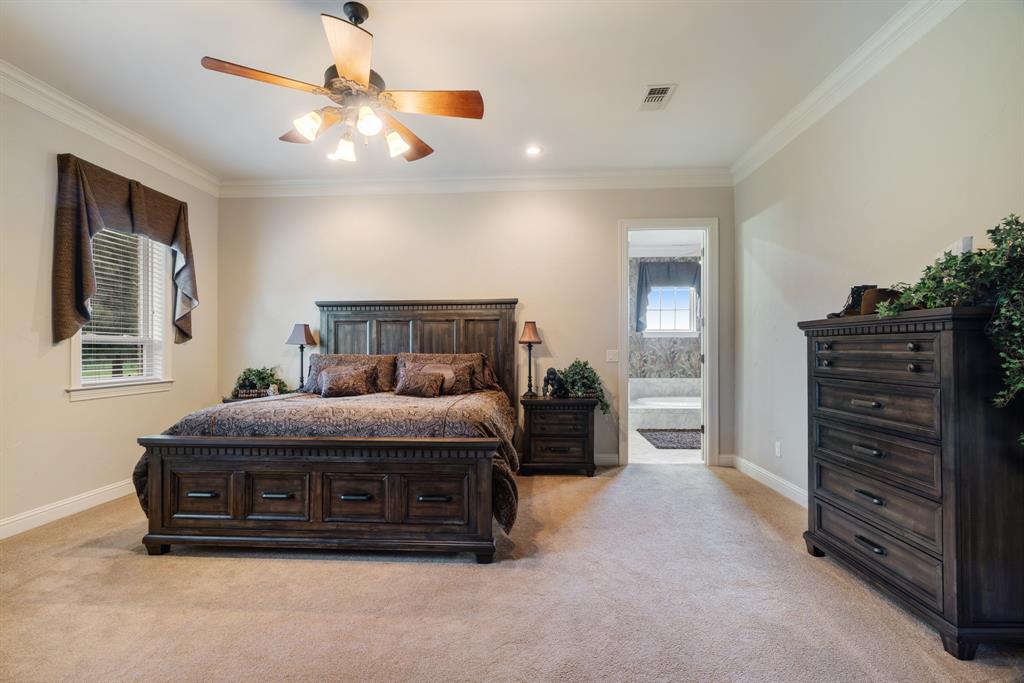 5500 Farm Road 195 Paris, TX 75462 - Photo 17 of 40 a spacious bedroom with a bed and a chandelier