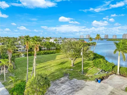an aerial view of city and lake with trees