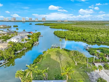an aerial view of a city with lots of residential buildings ocean and mountain view in back