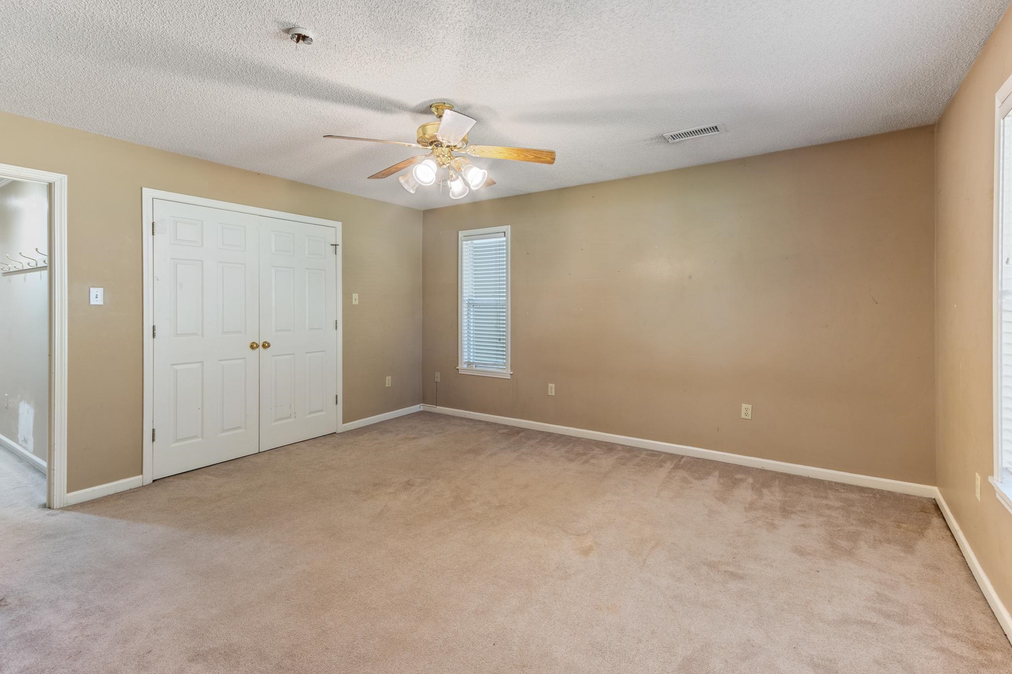 380 Woodbridge Road Somerville, TN 38068 - Photo 12 of 30 Unfurnished bedroom with light carpet, a textured ceiling, a closet, and ceiling fan