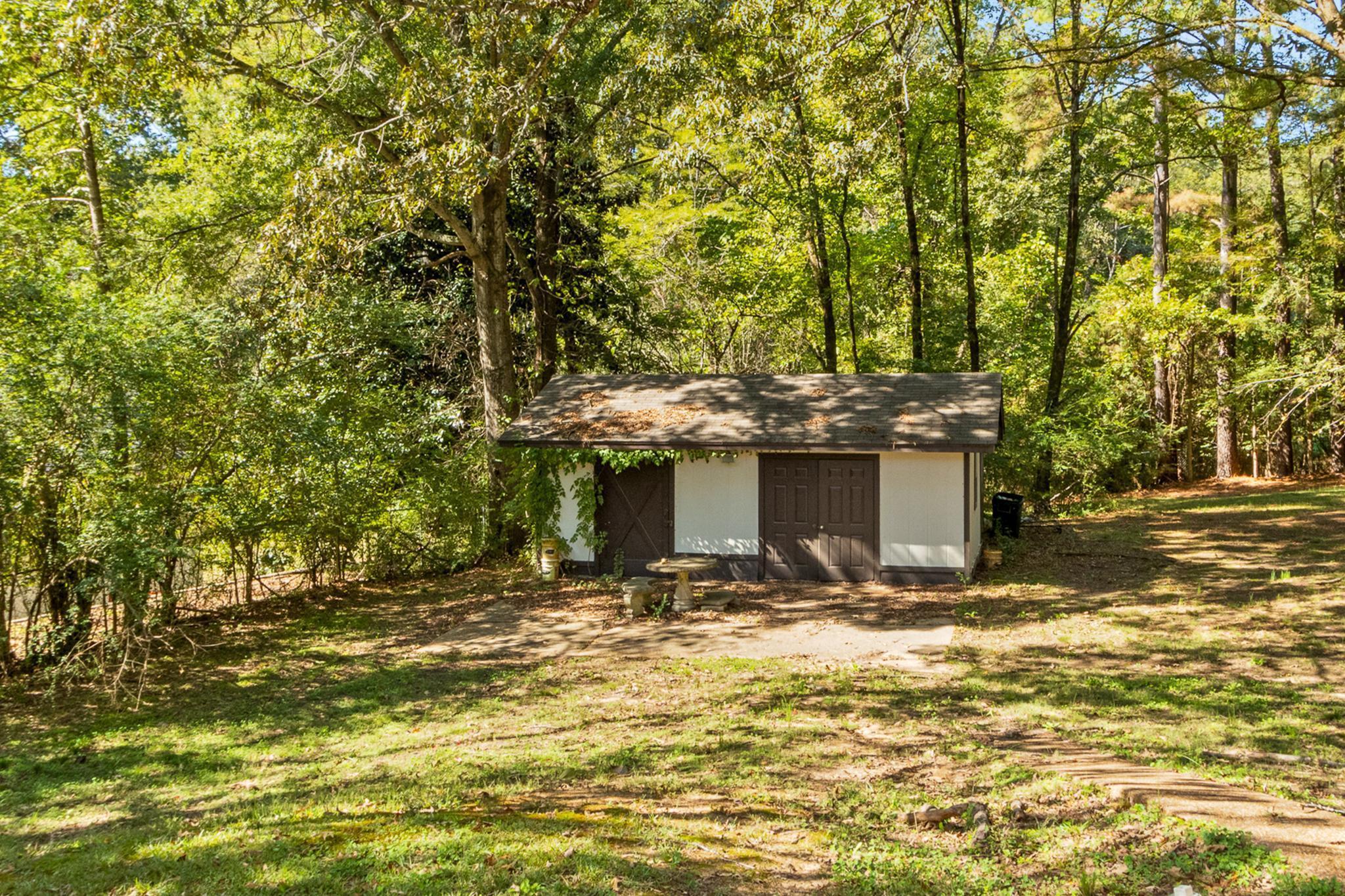 380 Woodbridge Road Somerville, TN 38068 - Photo 27 of 30 View of green lawn with a shed and a view of trees