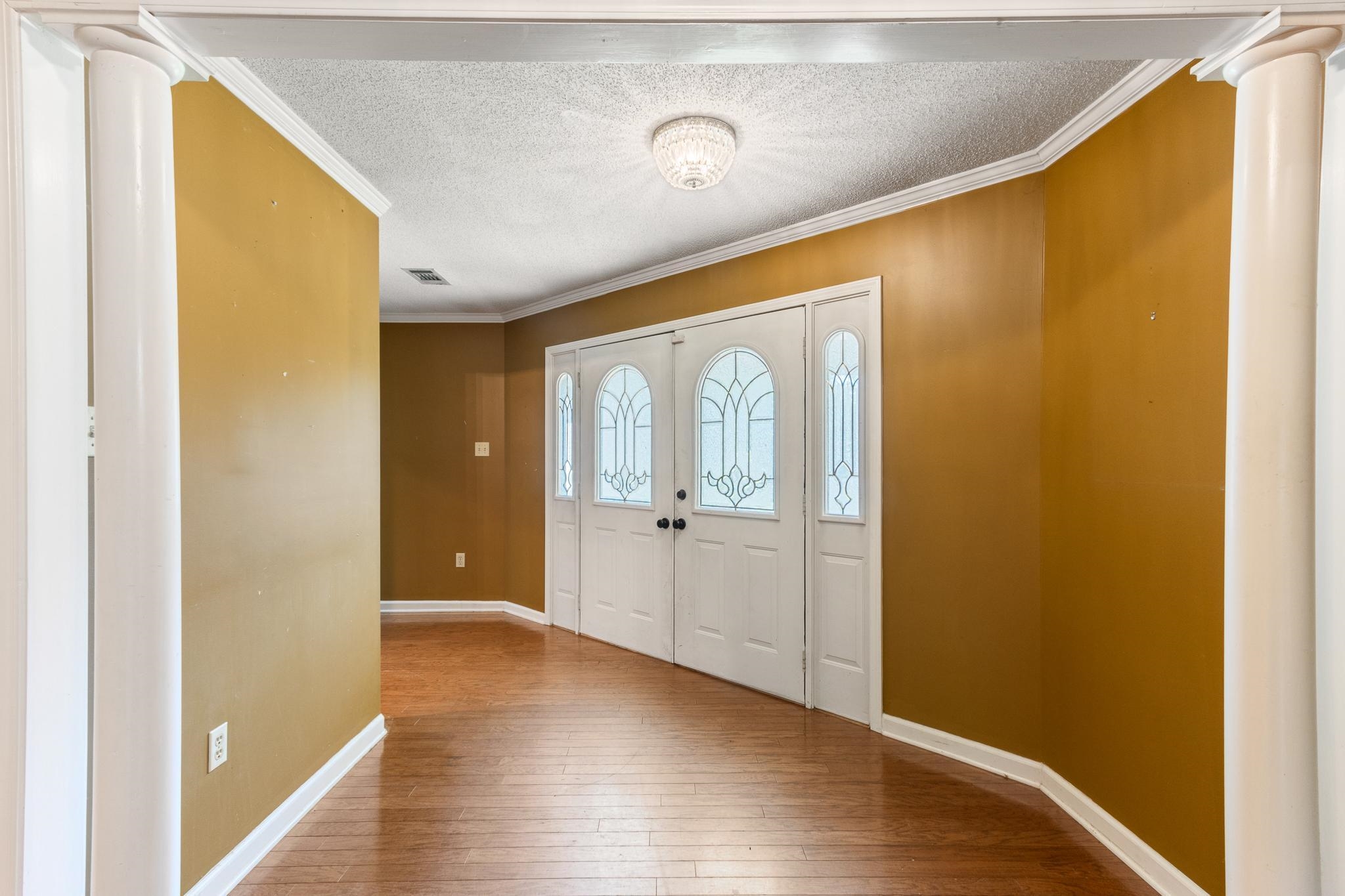 380 Woodbridge Road Somerville, TN 38068 - Photo 5 of 30 Entrance foyer with ornamental molding, ornate columns, a textured ceiling, and wood-type flooring