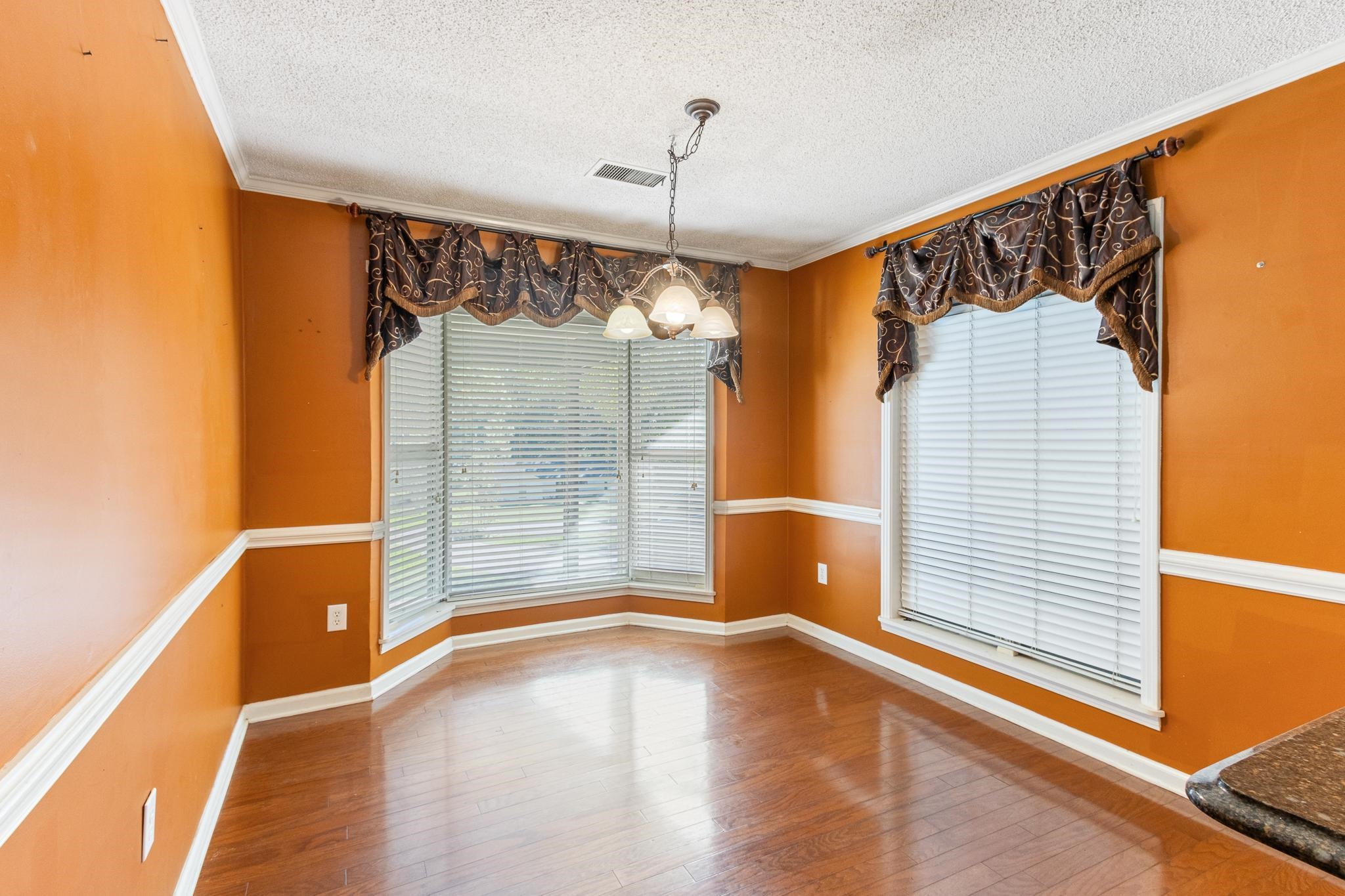 380 Woodbridge Road Somerville, TN 38068 - Photo 9 of 30 Unfurnished dining area with a textured ceiling, ornamental molding, a chandelier, and hardwood / wood-style flooring