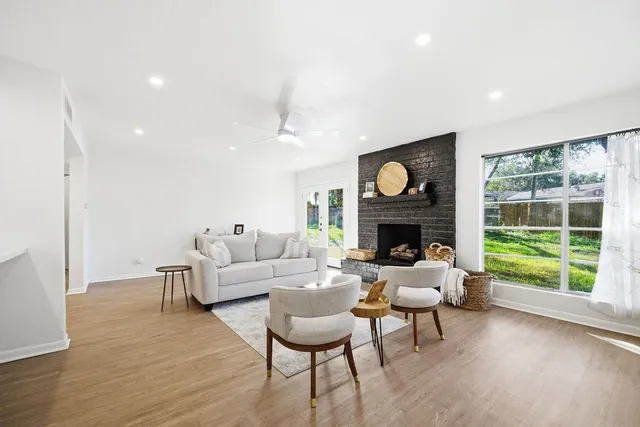 a living room with furniture a fireplace and a floor to ceiling window