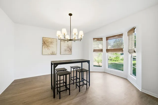 a view of empty room with wooden floor and windows