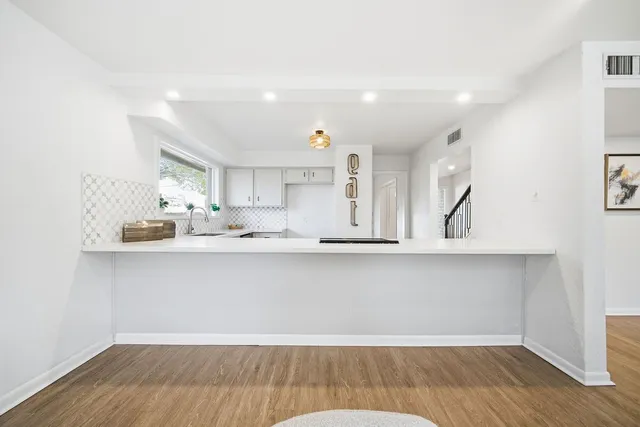 a kitchen with stainless steel appliances cabinets and wooden floor