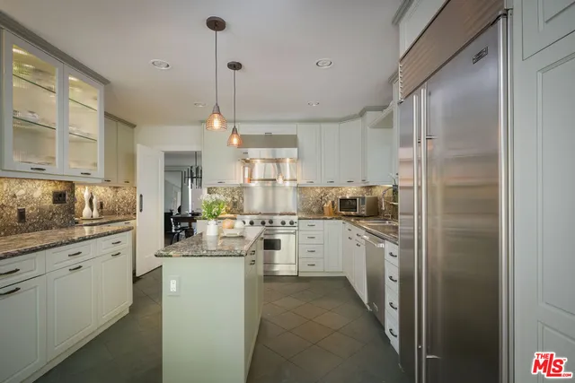 a kitchen with stainless steel appliances granite countertop a sink and a stove