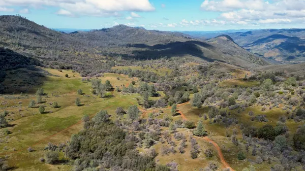 a view of mountains in middle of the green field