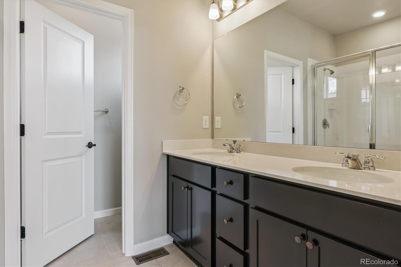 6720 Merseyside Lane Castle Pines, CO 80108 - Photo 13 of 24 a bathroom with a double vanity sink mirror and double