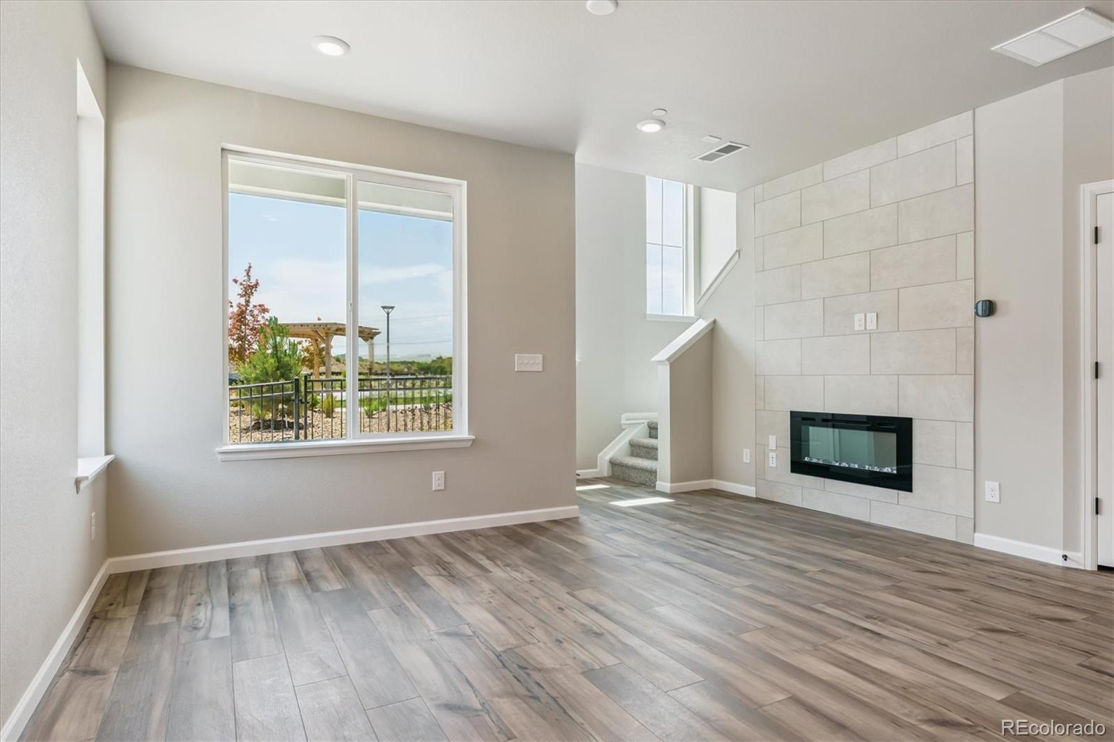 6720 Merseyside Lane Castle Pines, CO 80108 - Photo 8 of 24 an empty room with window and wooden floor