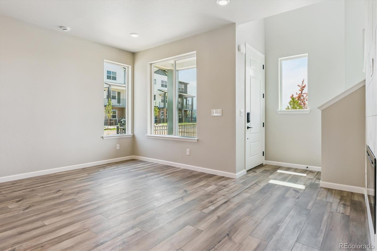 6720 Merseyside Lane Castle Pines, CO 80108 - Photo 9 of 24 an empty room with wooden floor and windows