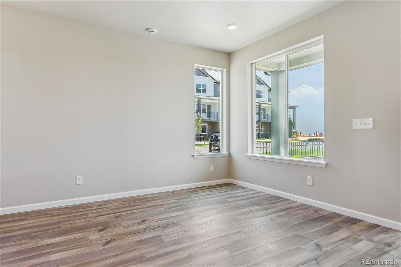 6720 Merseyside Lane Castle Pines, CO 80108 - Photo 10 of 24 a view of an empty room with wooden floor and a window