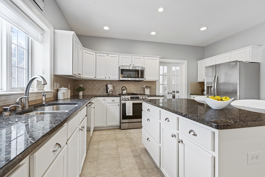 5 Apple Rock Road Millis, MA 02054 - Photo 12 of 42 a kitchen with granite countertop a sink a stove and cabinets