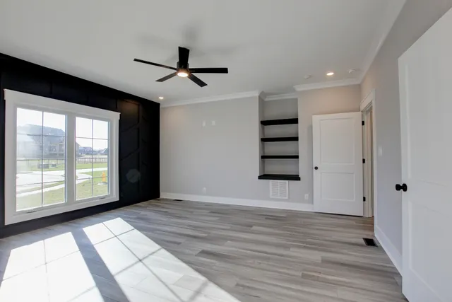 a view of empty room with wooden floor and window