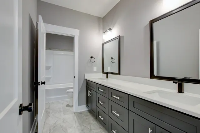 an empty room with chandelier fan and windows
