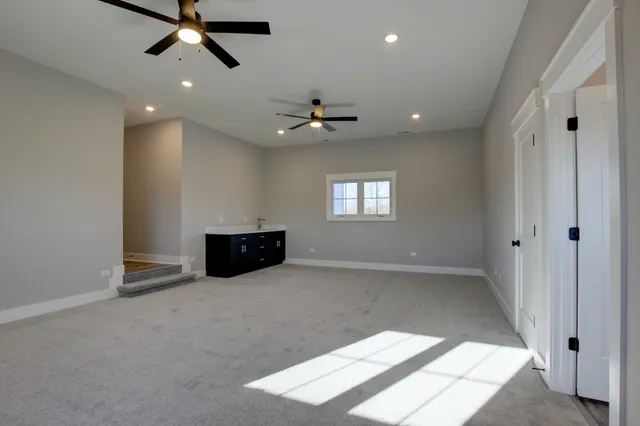an empty room with wooden floor closet and windows